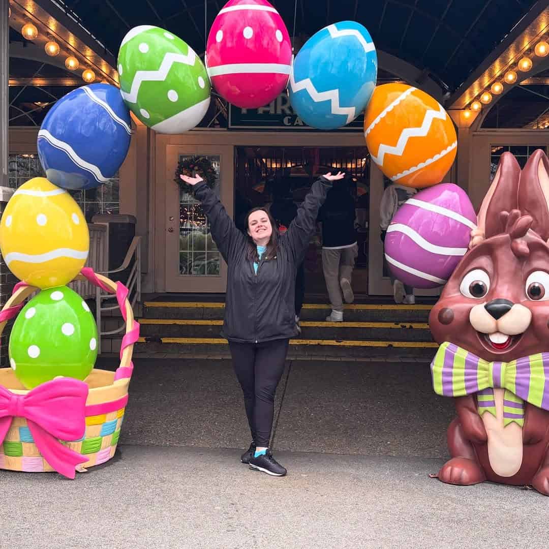 Woman posing above the easter arcway featuring giant easter eggs.
